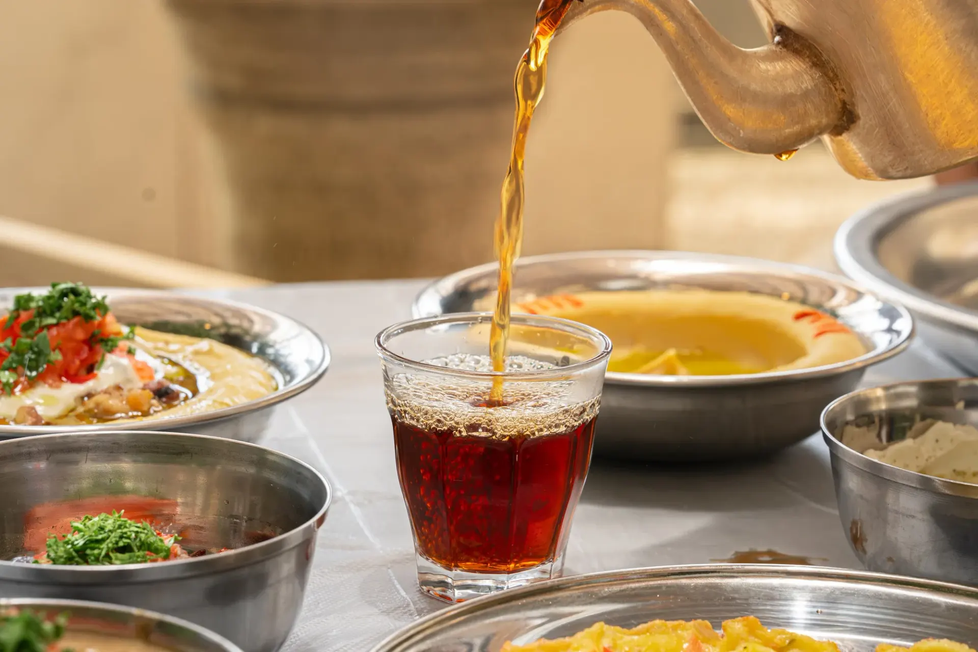 Tea poured over a breakfast spread in the courtyard at Al Wazzan & Al Shamali.