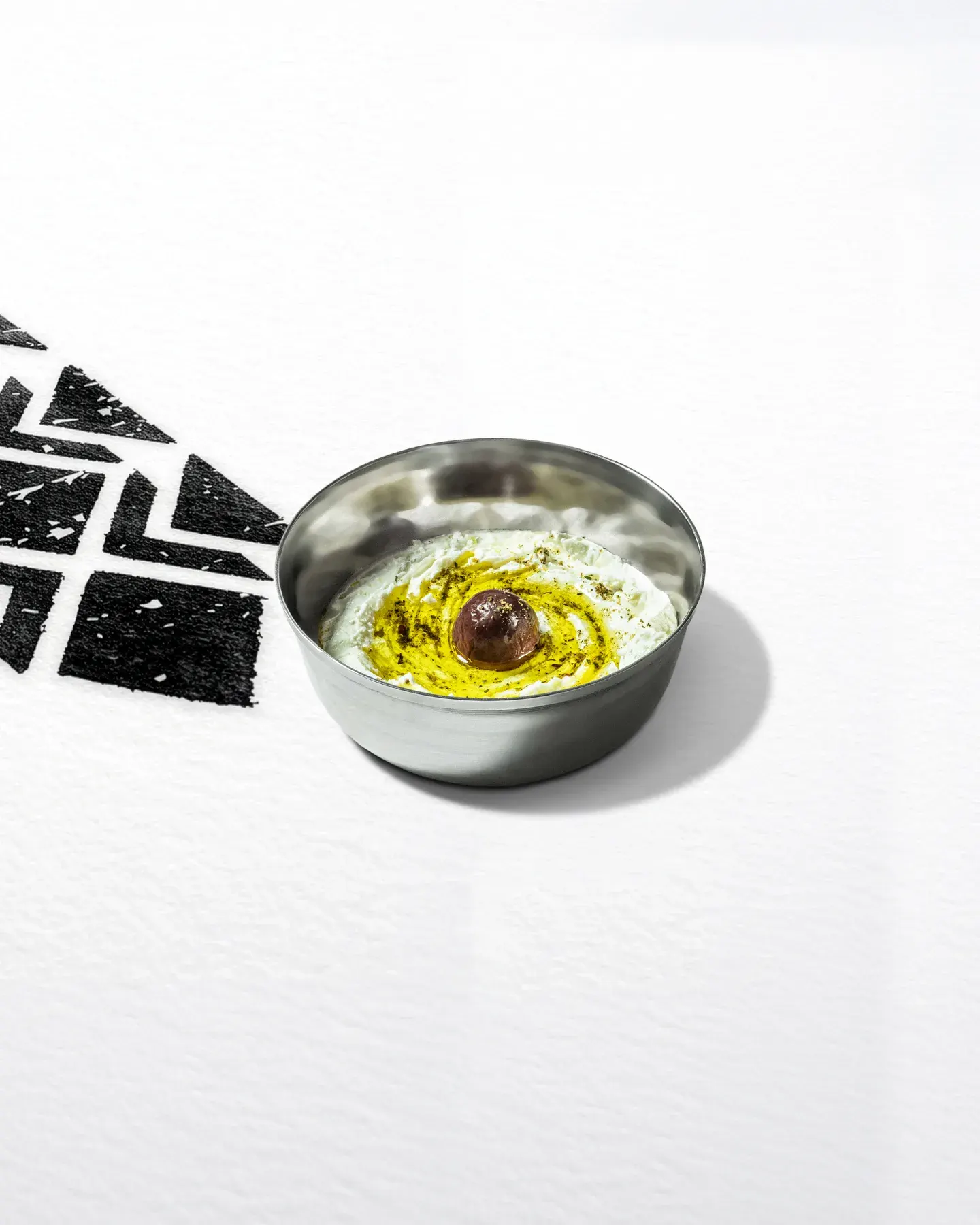 A bowl of labneh pooled with olive oil.