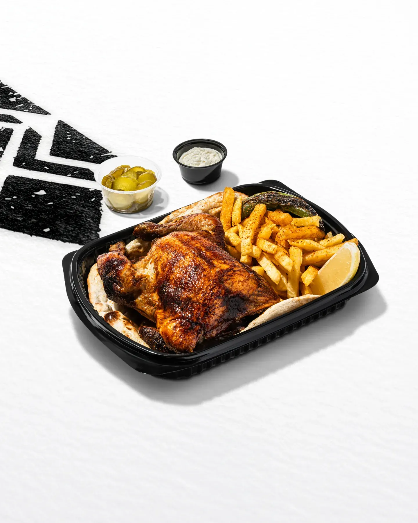 Roast chicken with fries in a takeaway tray.