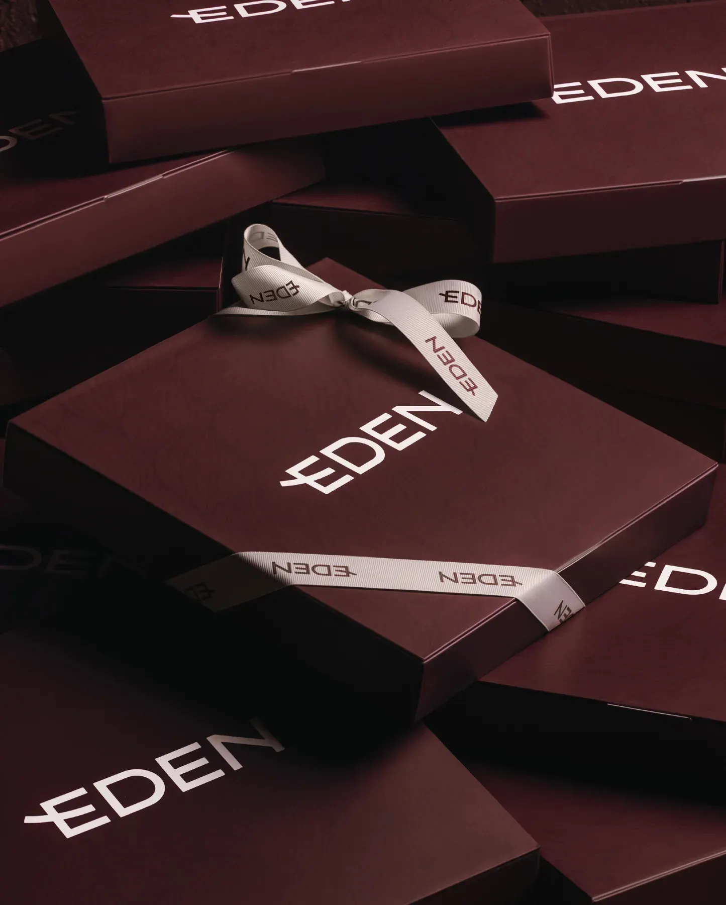 Eden gift boxes heaped together and tied with the cream ribbon.