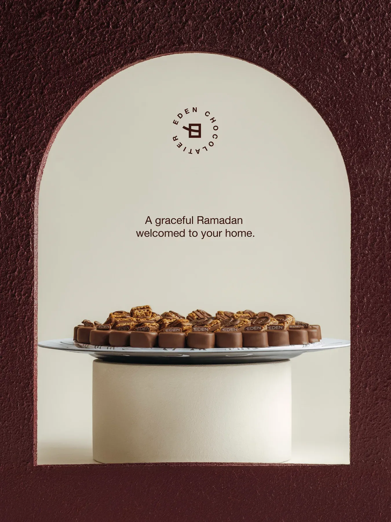 A platter of Eden chocolates on a plinth inside a cream arch, with the Ramadan greeting.