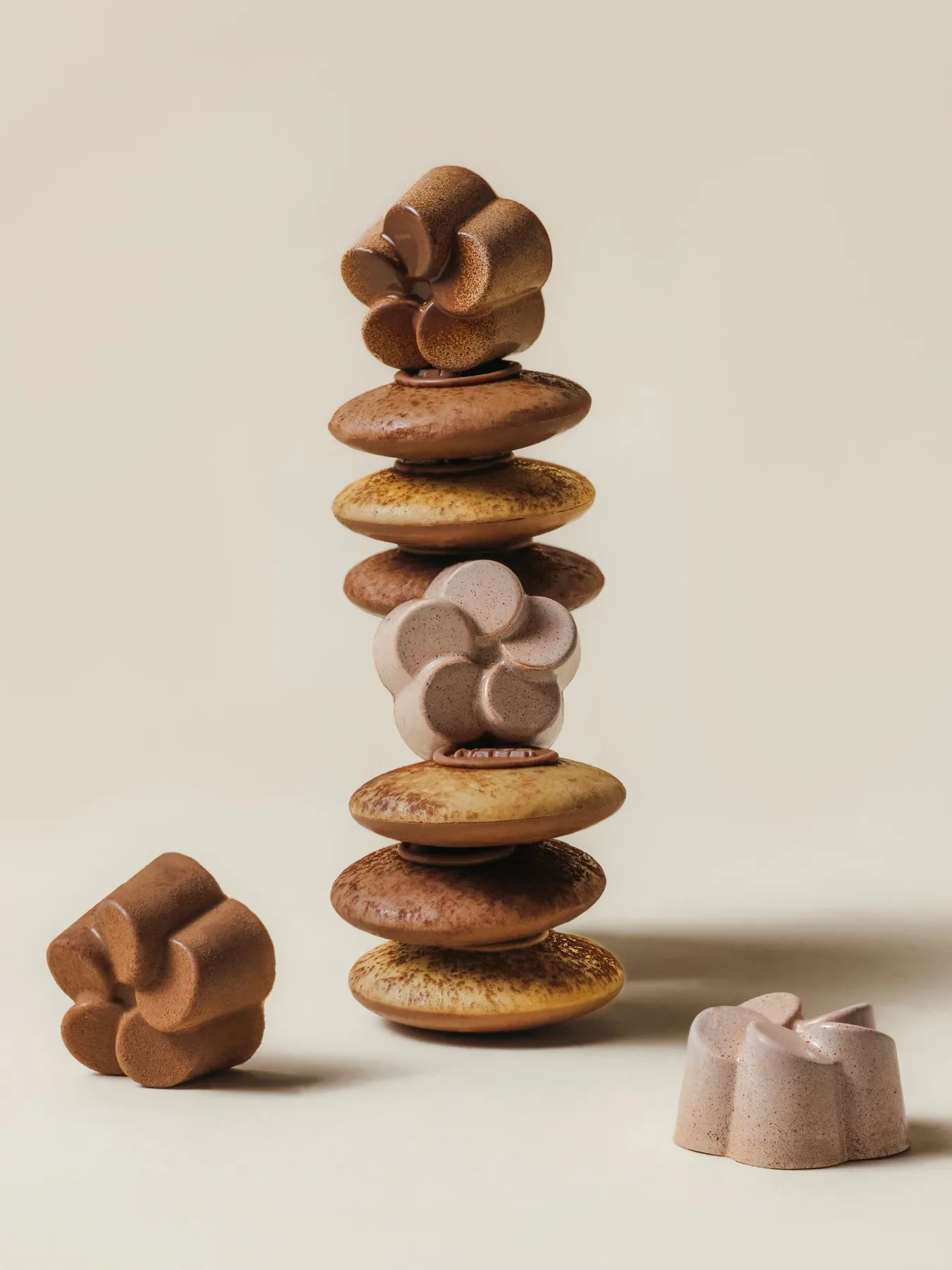 A balanced tower of assorted Eden chocolates on cream.