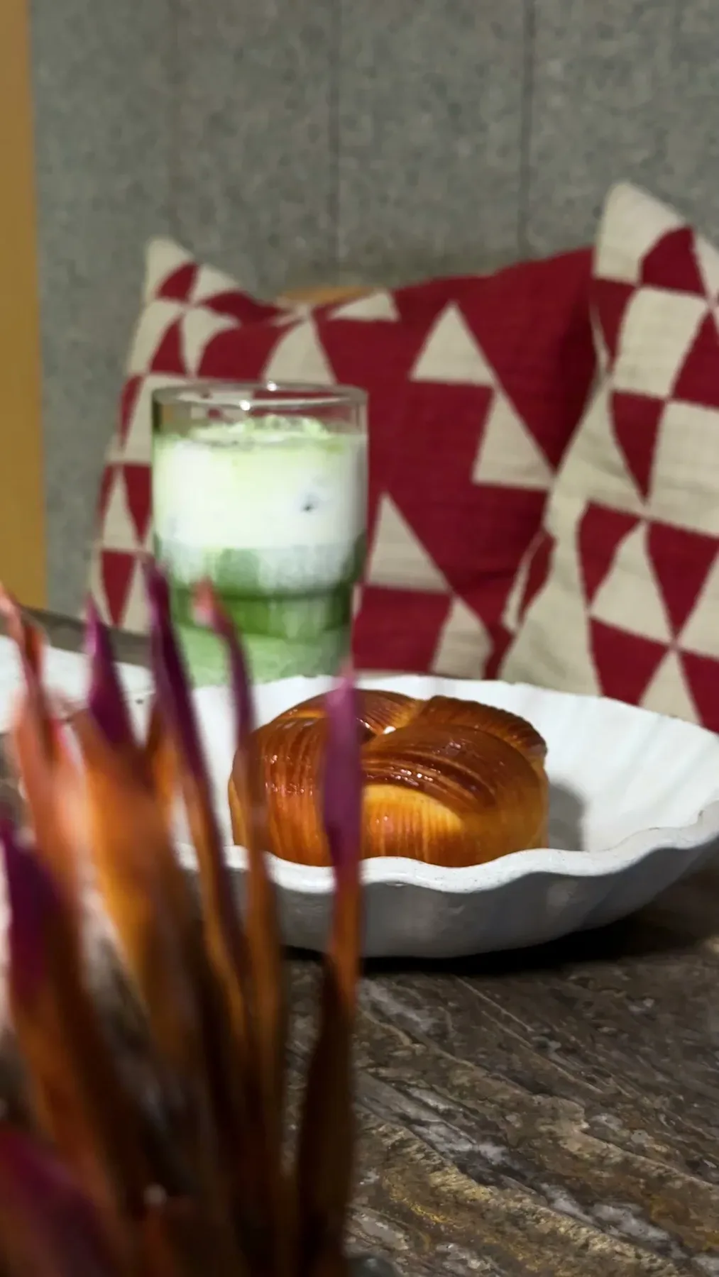 A layered matcha beside a laminated pastry on a Folio table.