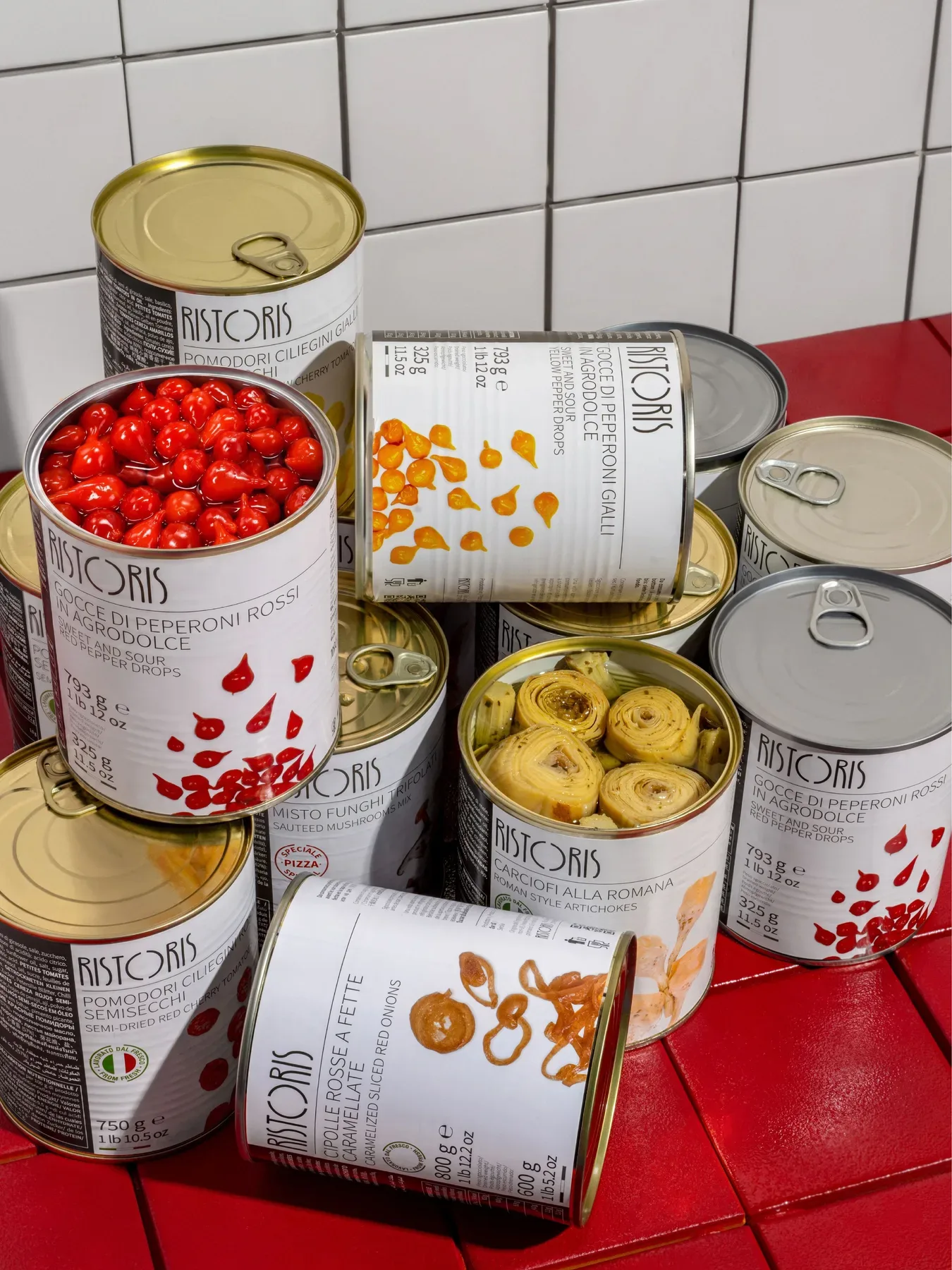 Open cans from the Ristoris range stacked on red tiles.