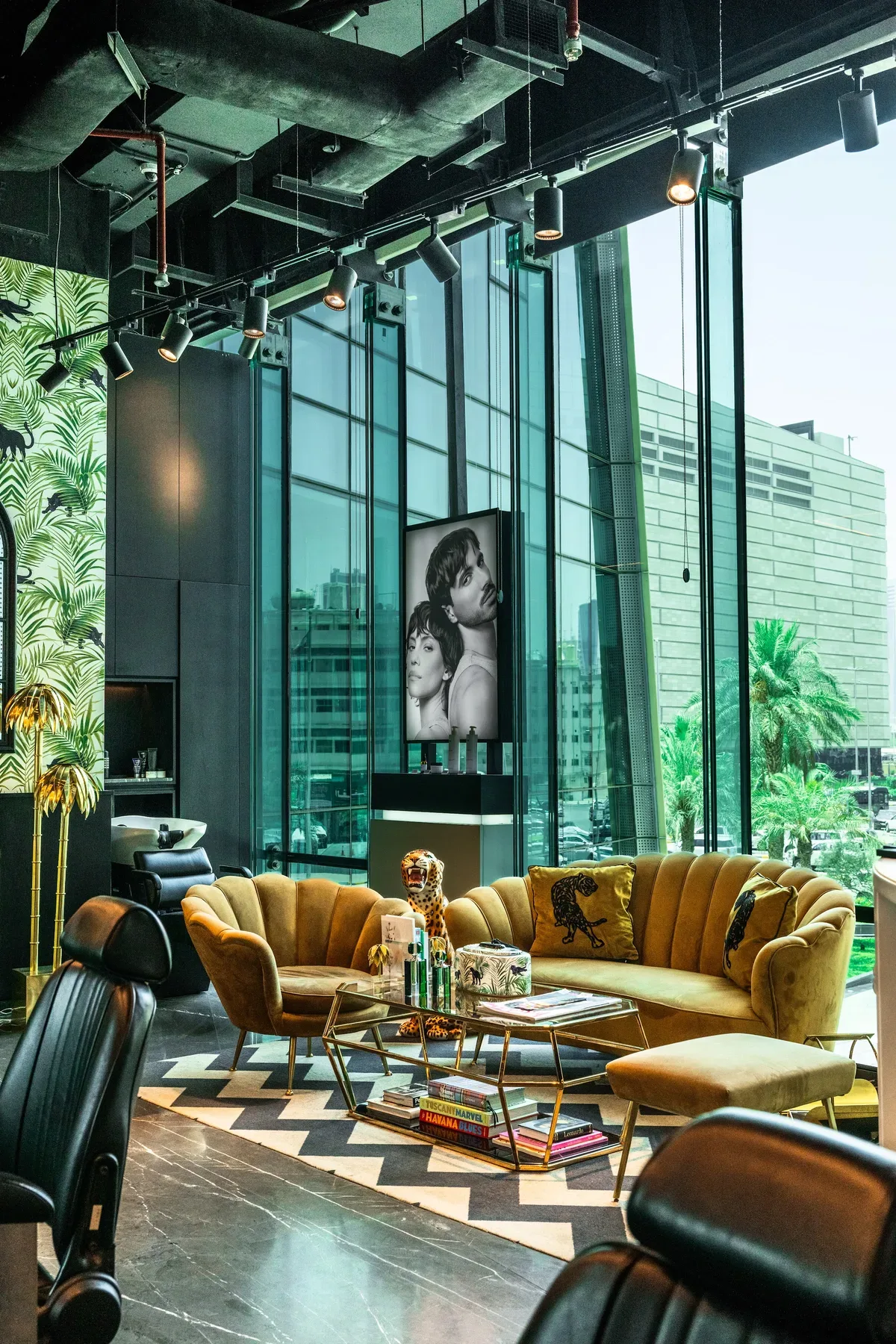 A barbershop lounge with velvet sofas against the glass facade.