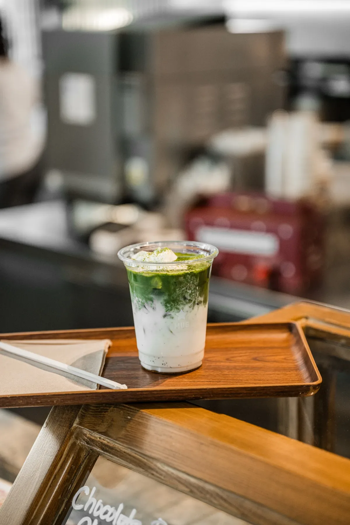An iced matcha on a wooden tray.