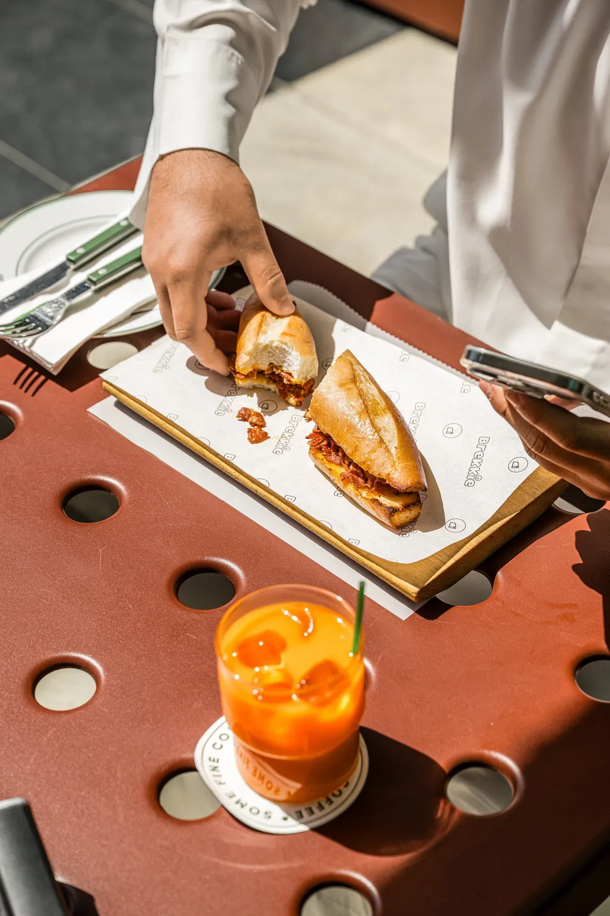 A toasted sandwich and a fresh juice set down at the table.