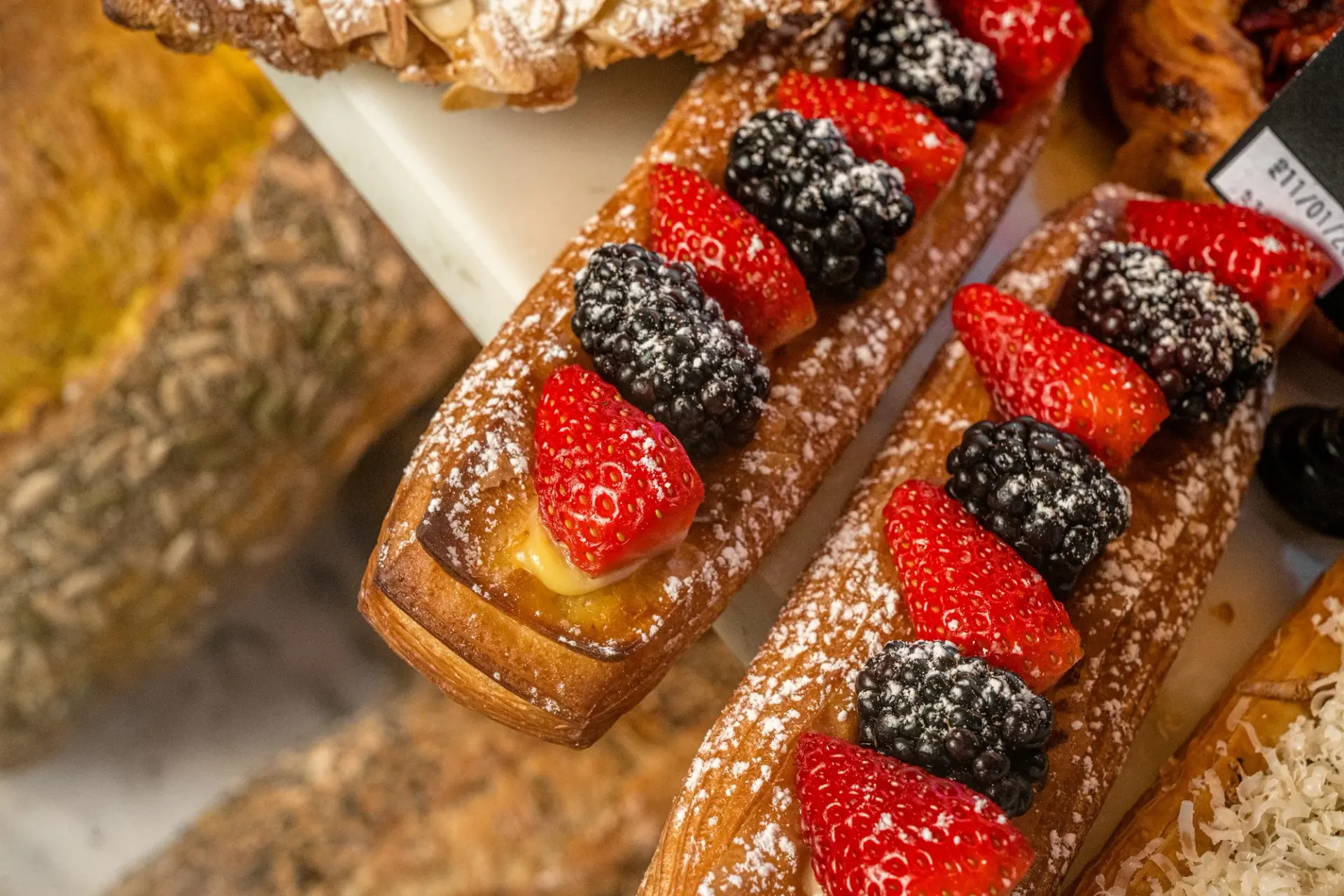 Pastry fingers topped with berries and dusted with sugar.