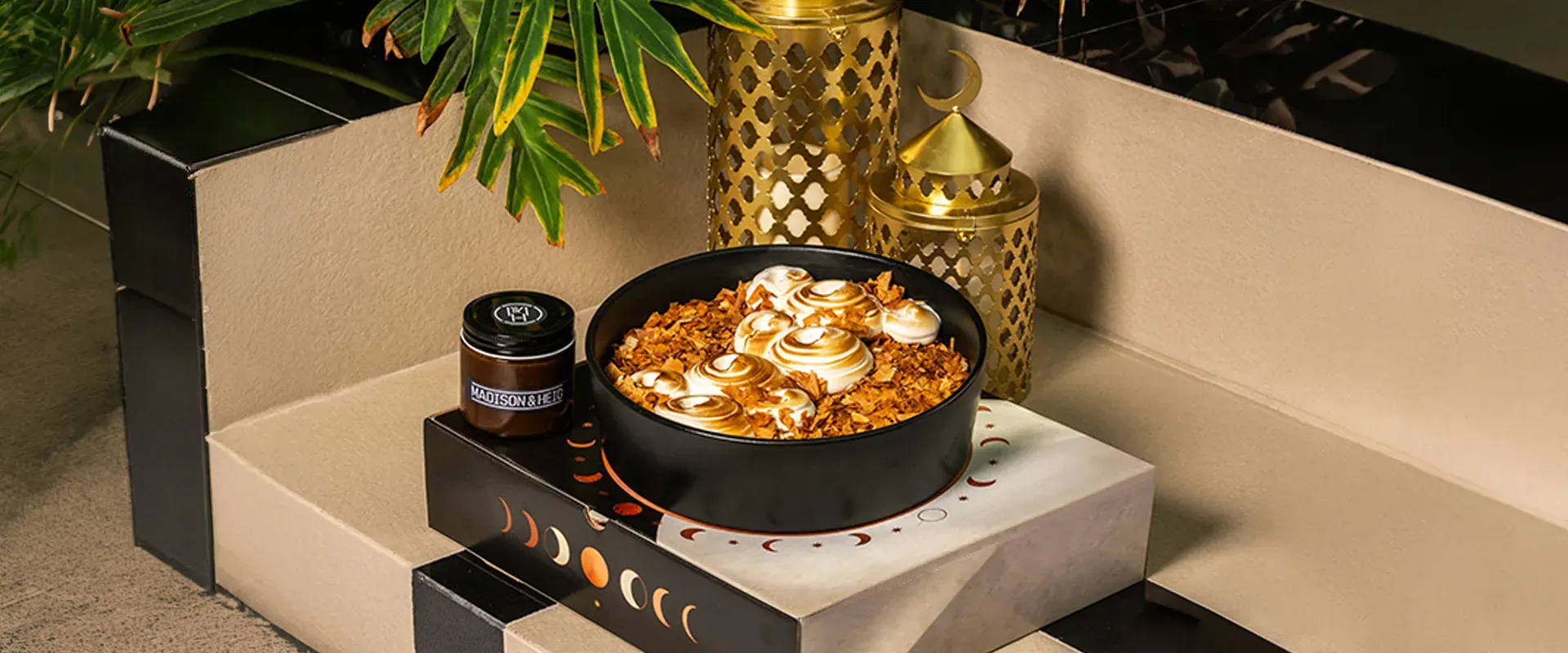 The Ramadan cake with gold lanterns and its packaging, the wide hero frame.