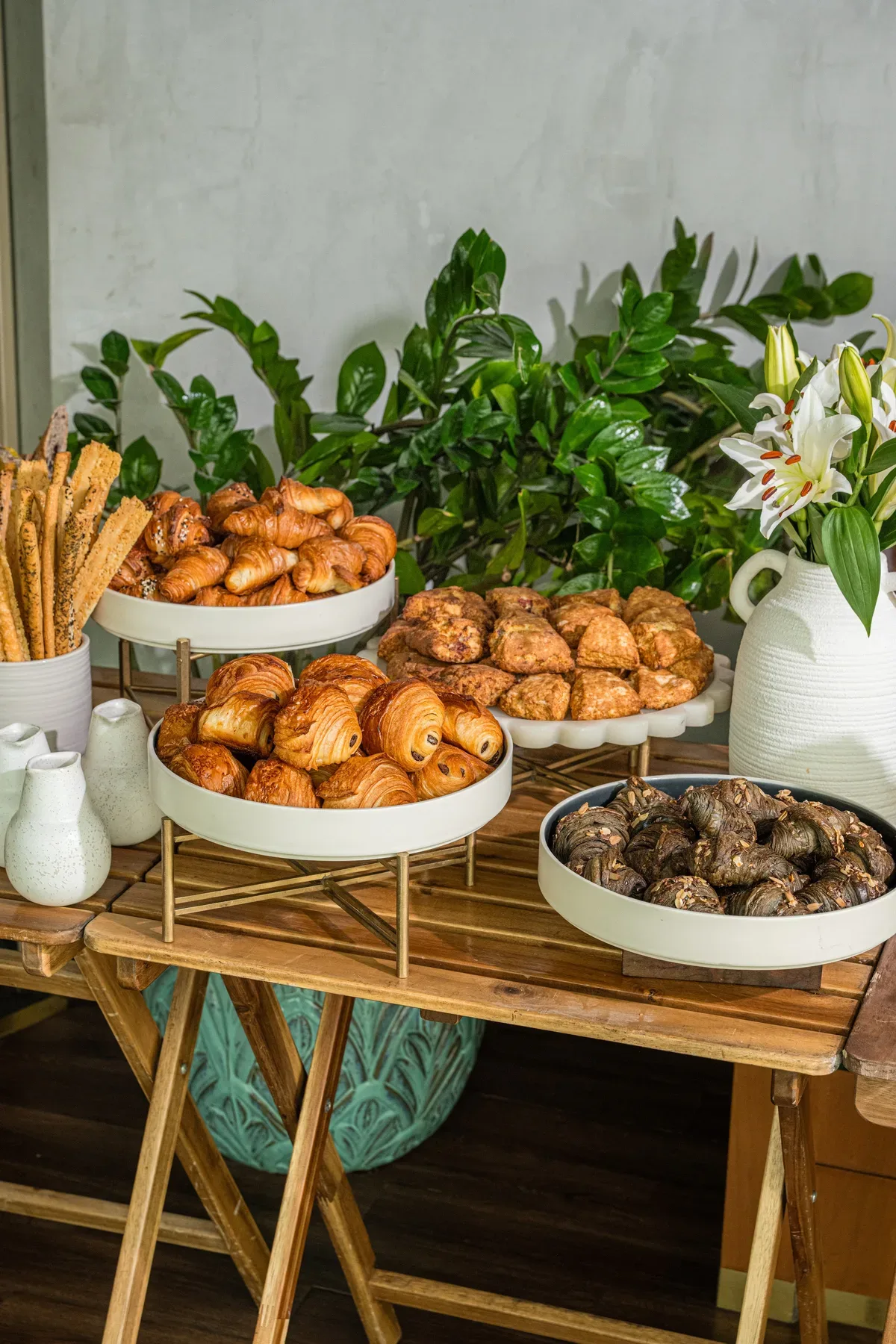A pastry stand framed by greenery at the catering setup.