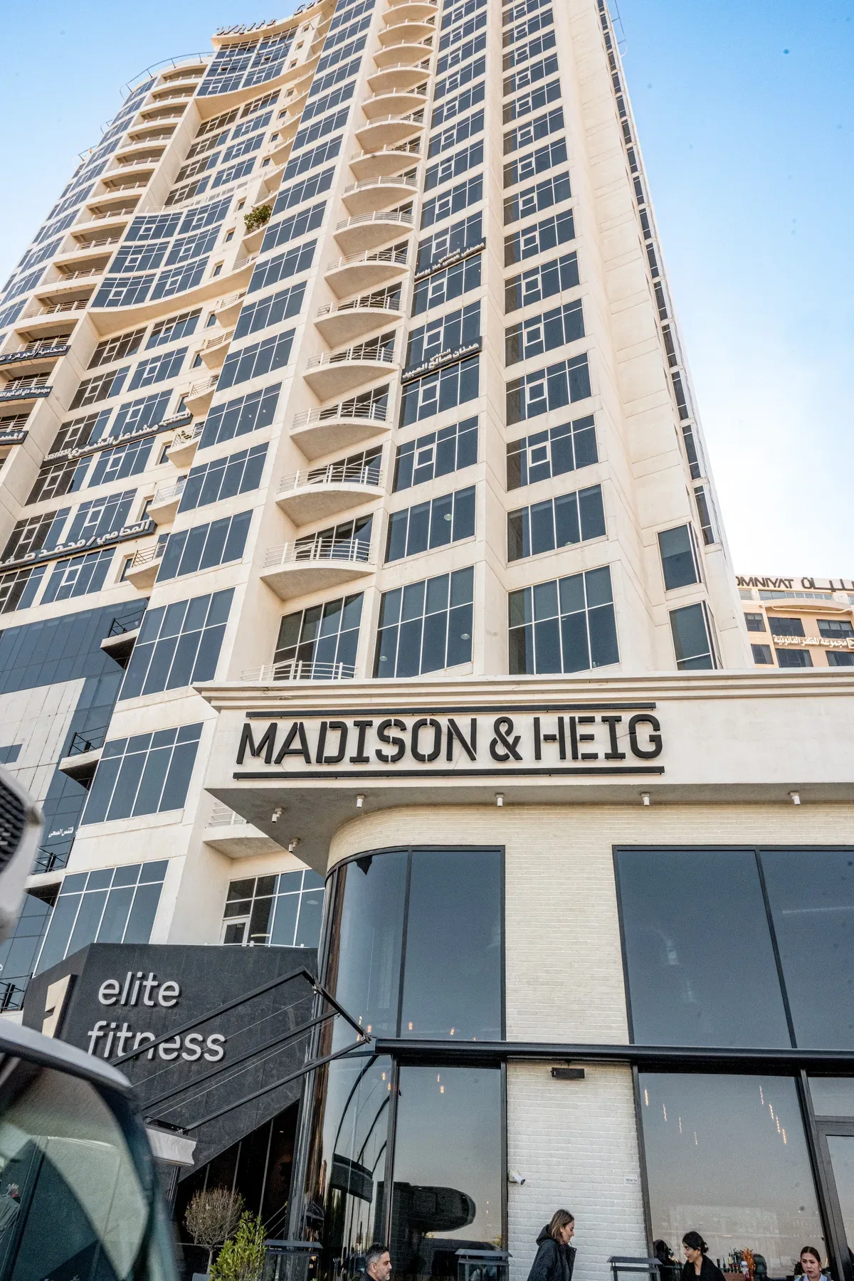 The Madison & Heig sign on the building, against a clear sky.