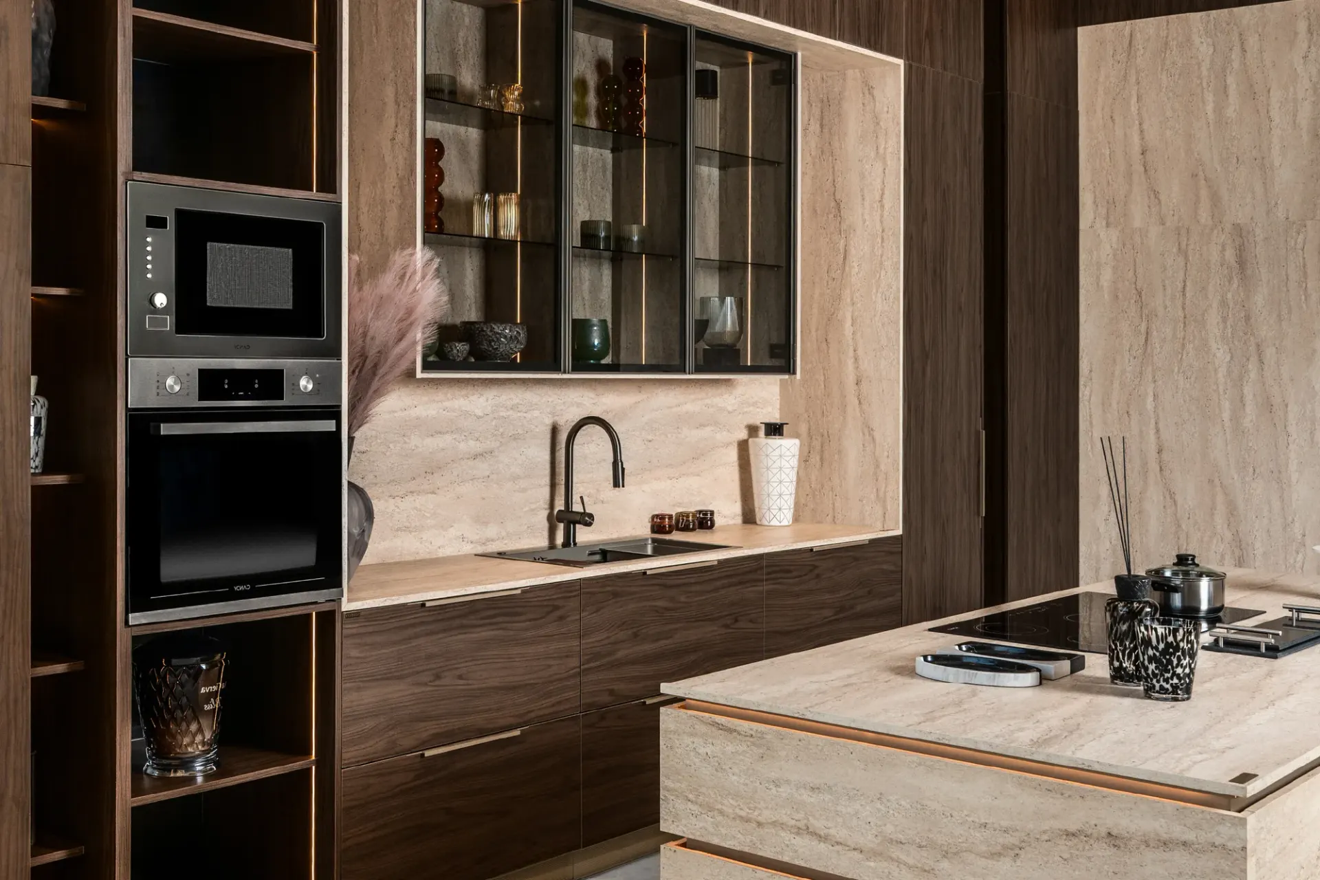A Novelty kitchen in walnut and travertine, with a floating island and lit glass cabinets.