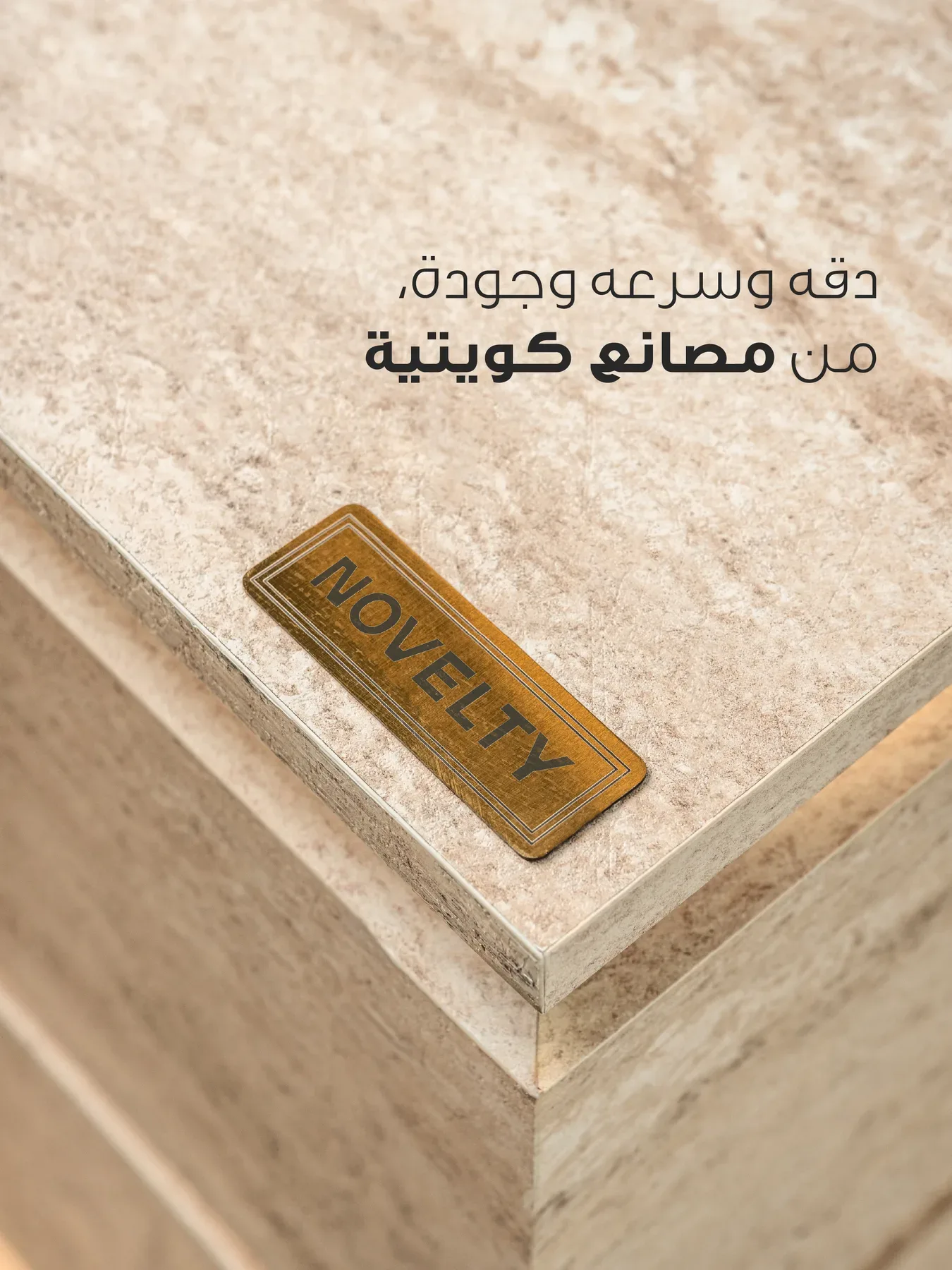 A travertine counter edge with the brass Novelty plaque. The Arabic line reads precision, speed and quality from Kuwaiti factories.