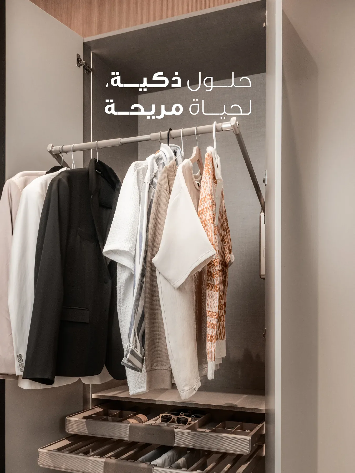 An open wardrobe with a pull down rail and tray drawers. The Arabic line reads smart solutions for a comfortable life.