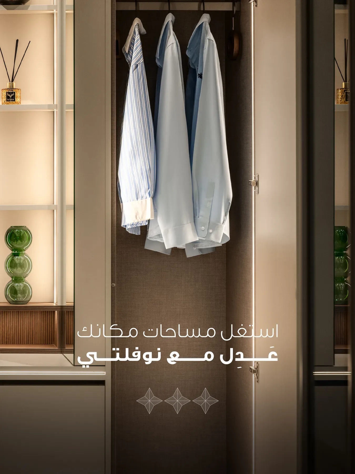 A lit wardrobe bay with shirts on the rail and glass shelving.
