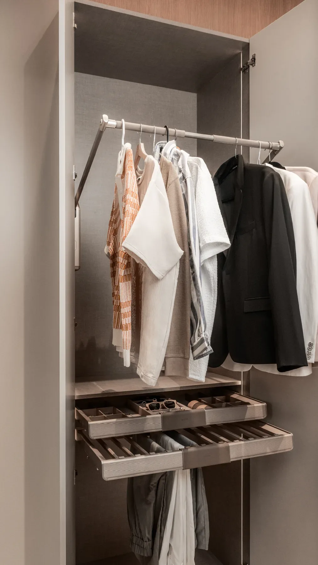 A wardrobe bay with a hanging rail and tray drawers, from the story set.