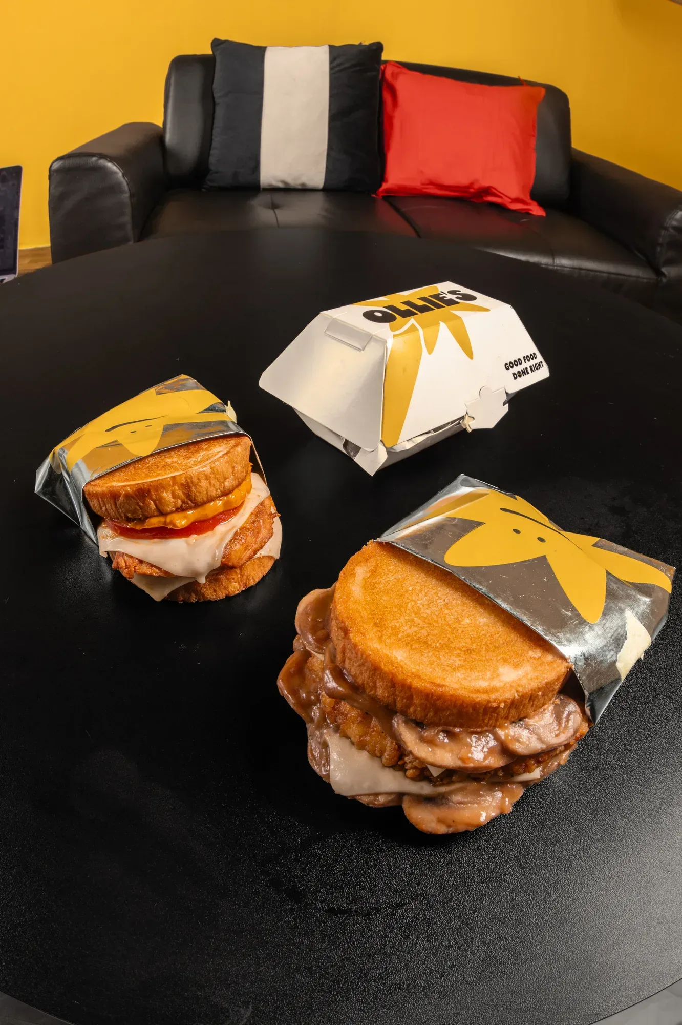 Two boxes open on the black table, lit so the bread still reads under the branding.