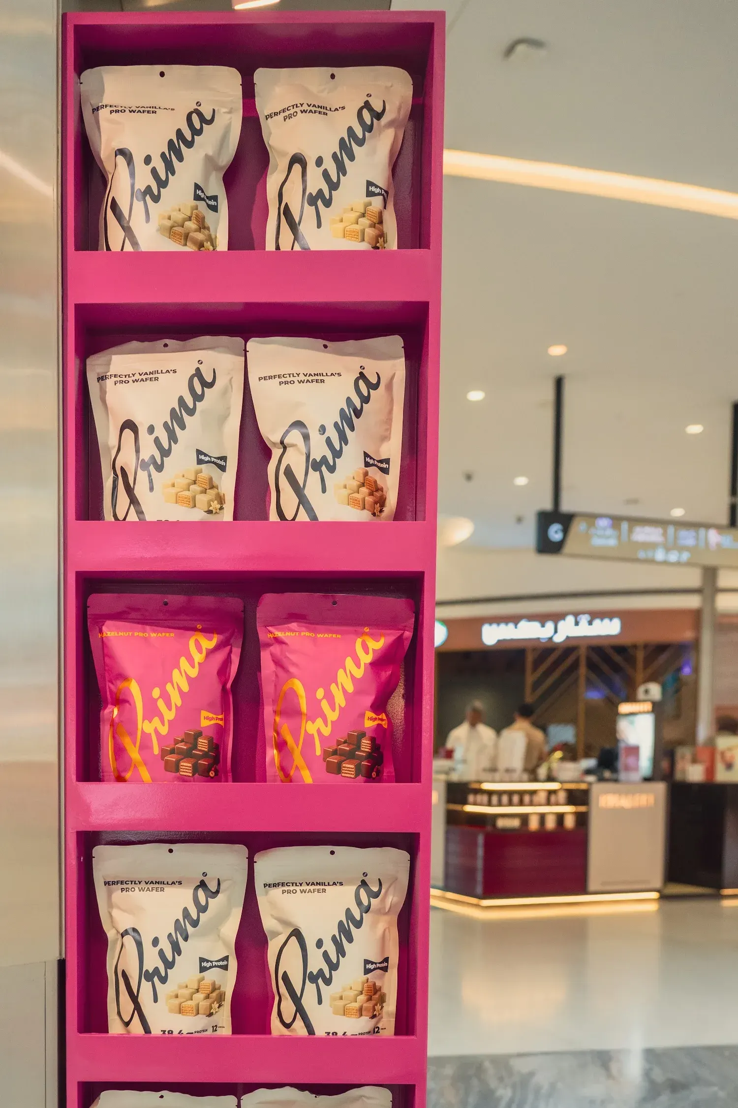 A pink shelf of Perfectly Vanilla and Hazelnut pouches on the side of the Prima pop-up.