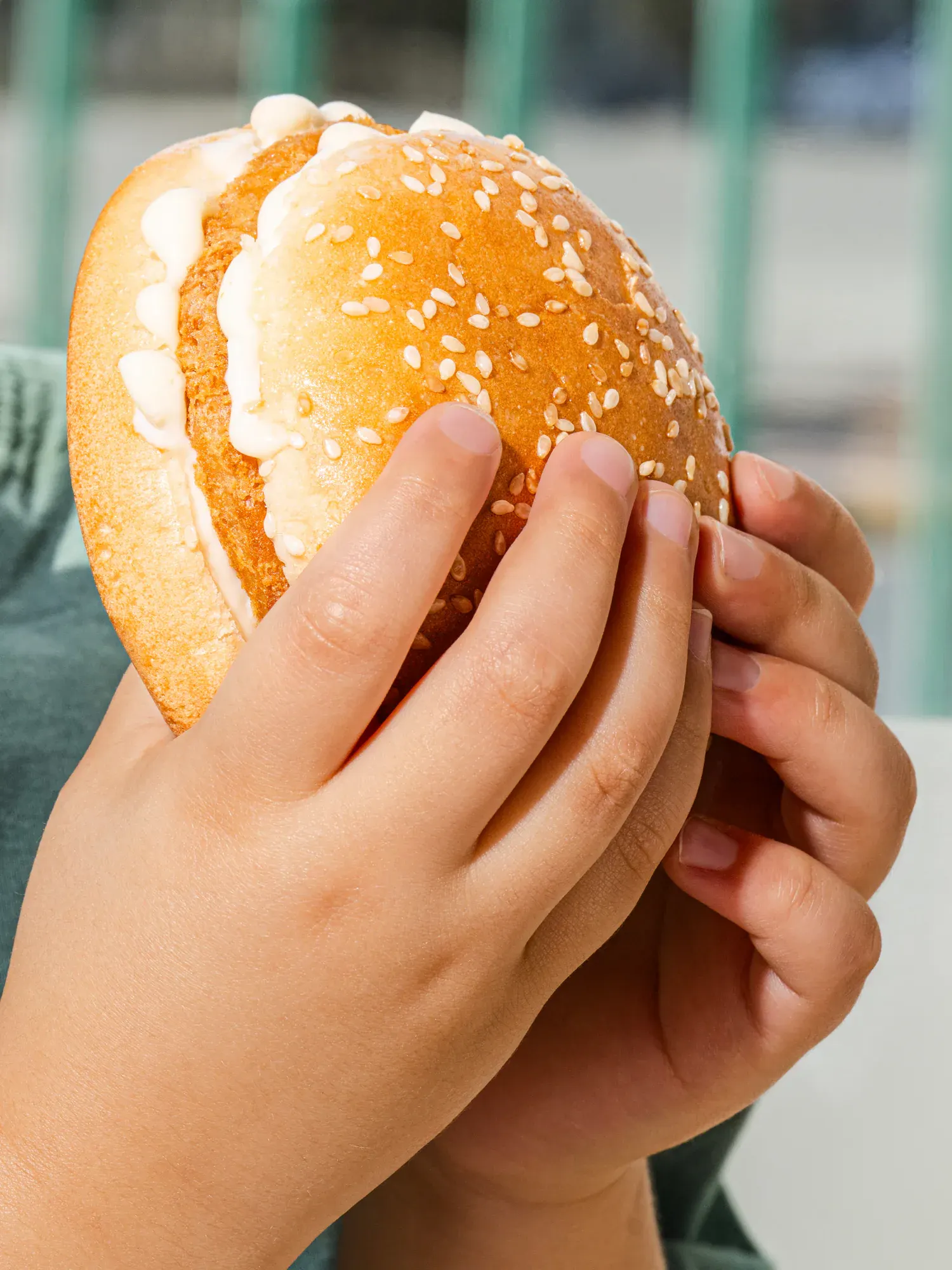 A child holding the burger, shot at their height rather than ours.